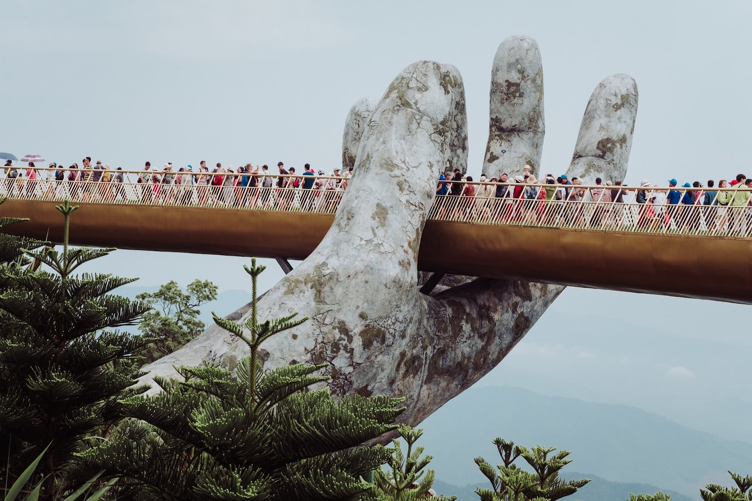 Hand Golden bridge in Vietnam on a cloudy day with lots on tourists