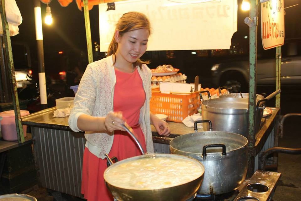 Woman street vendor preparing a soup at a night market