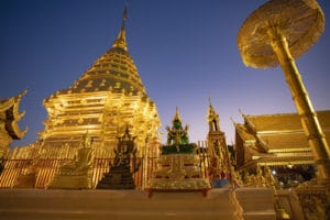 Visiting Doi Suthep Temple at night while watching the sunset above Chiang Mai in Thailand