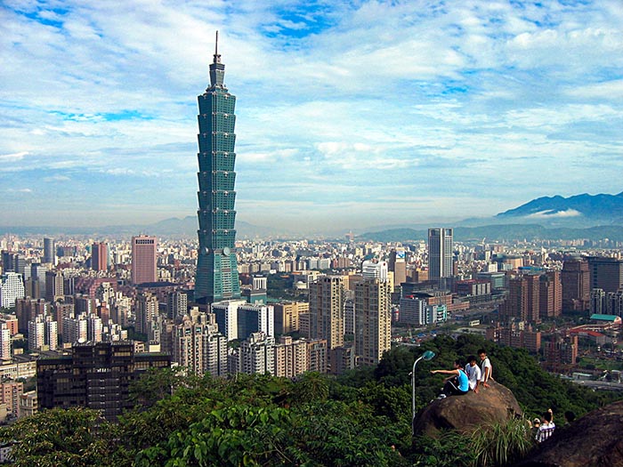 View above Taipei, Taiwan, with 3 boys on a rock seeing the Taiwanese skyline.