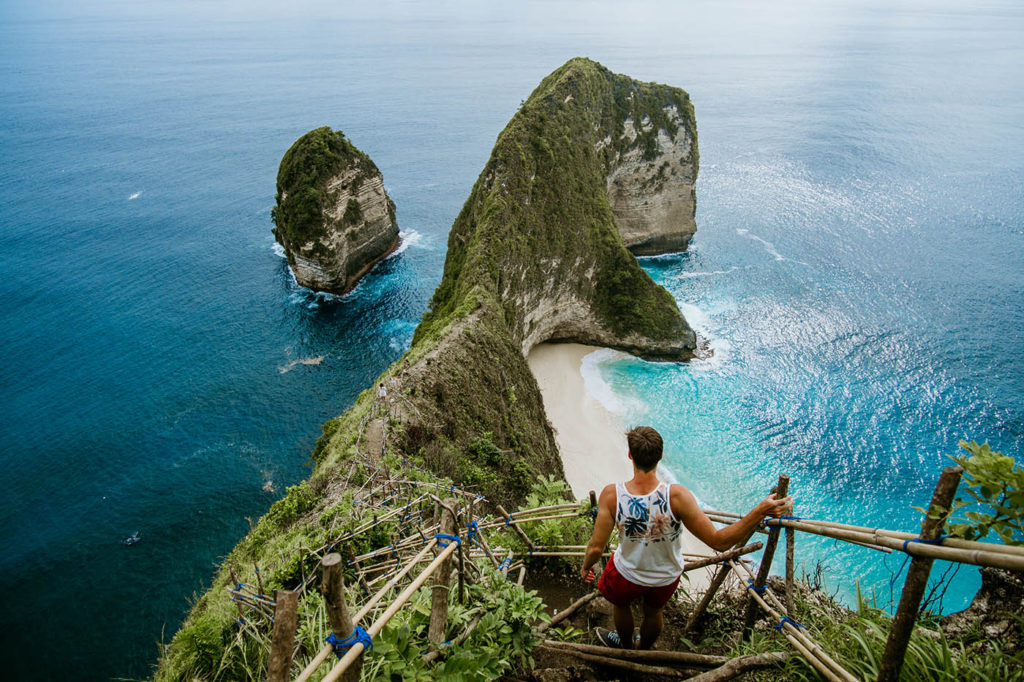 Man looking at the sea in Nusa Penida with blue waters in the background in Bali, Indonedia