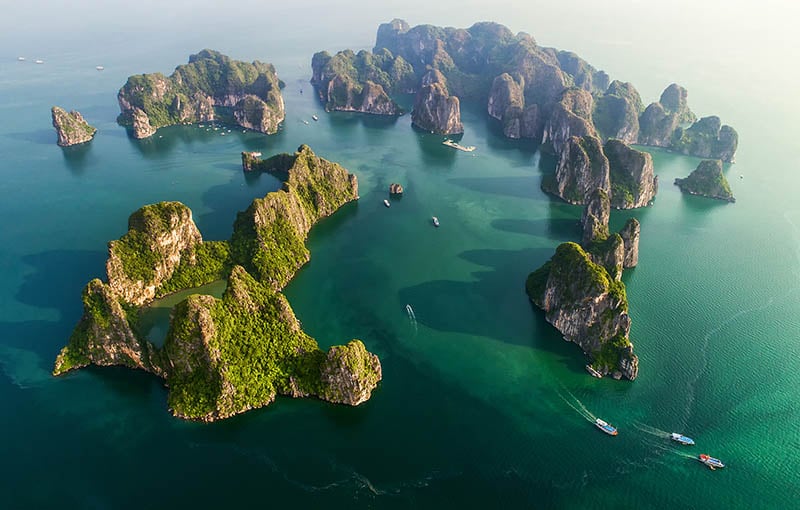 The natural rocks of Halong Bay, Vietnam, from above on a sunny day with clear blue water