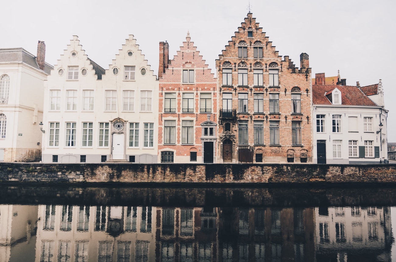 authentic red and white brick houses with their reflection on the water in Belgium