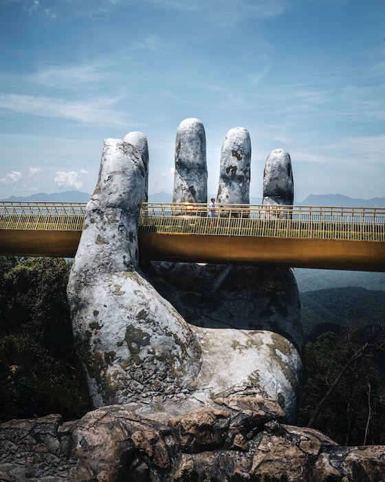 Hands stone figure holding a bridge