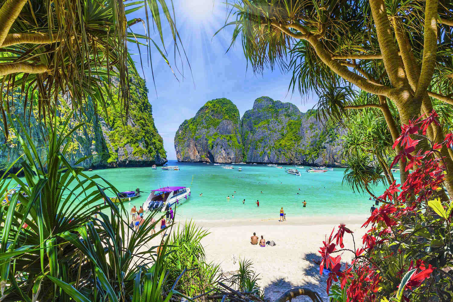Maya Bay in southern Thailand with tropical setting, turquoise water and tourists on the beach
