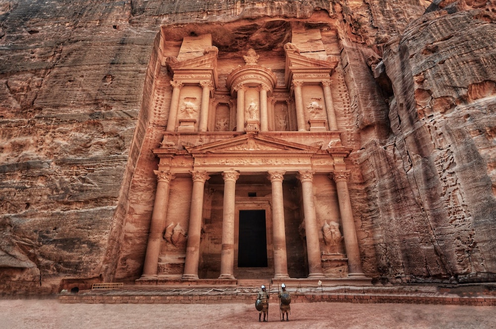 2 gladiators standing in front of an ancient building in Petra, Jordan