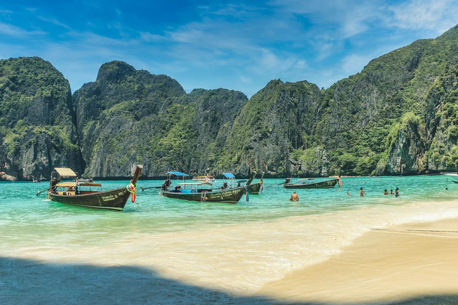 Beach on Krabi with long tail boats and mountains in the background