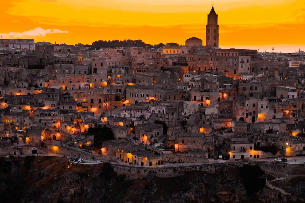 Matera at night with lots of lights during sunset - Best Time to Visit Matera