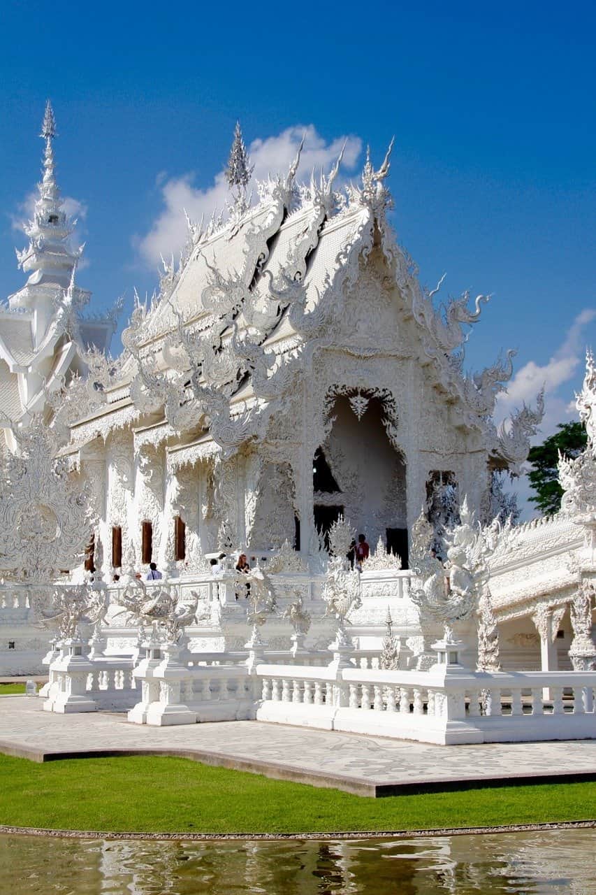 Intricate white temple under blue sky.