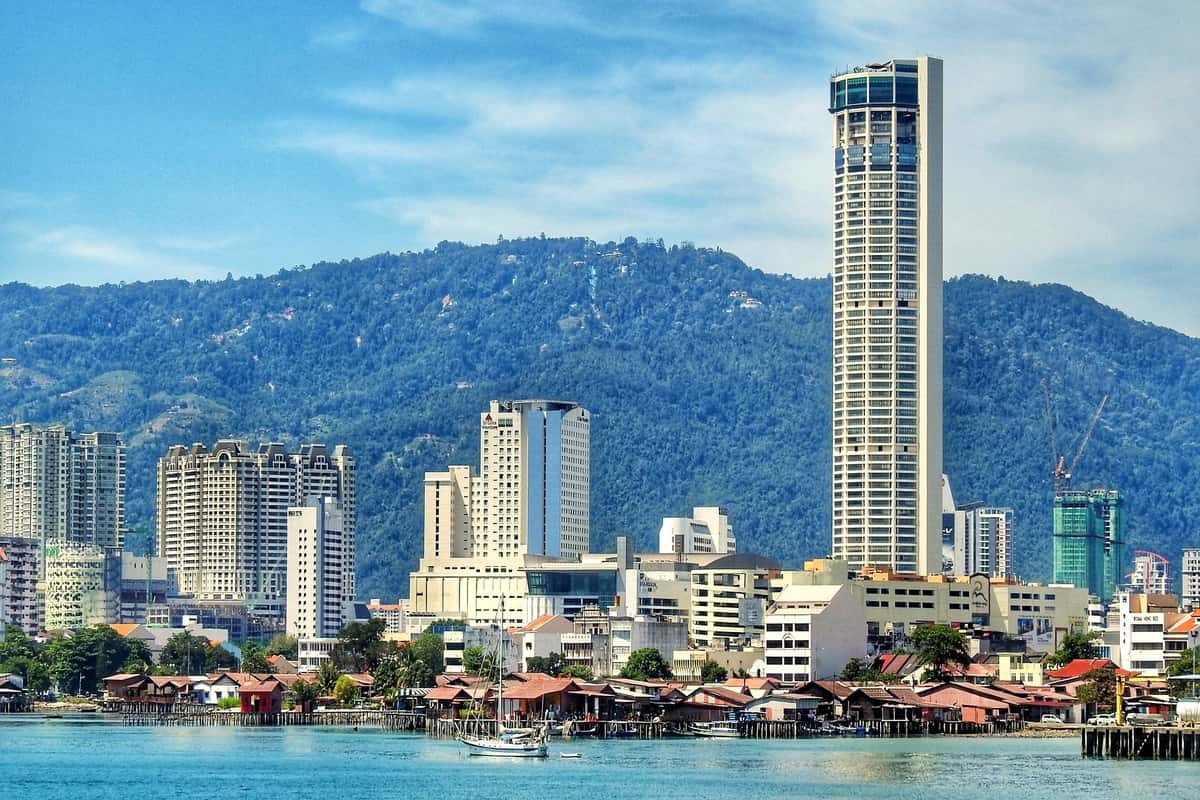 places in Penang - Cityscape with modern buildings and hill.