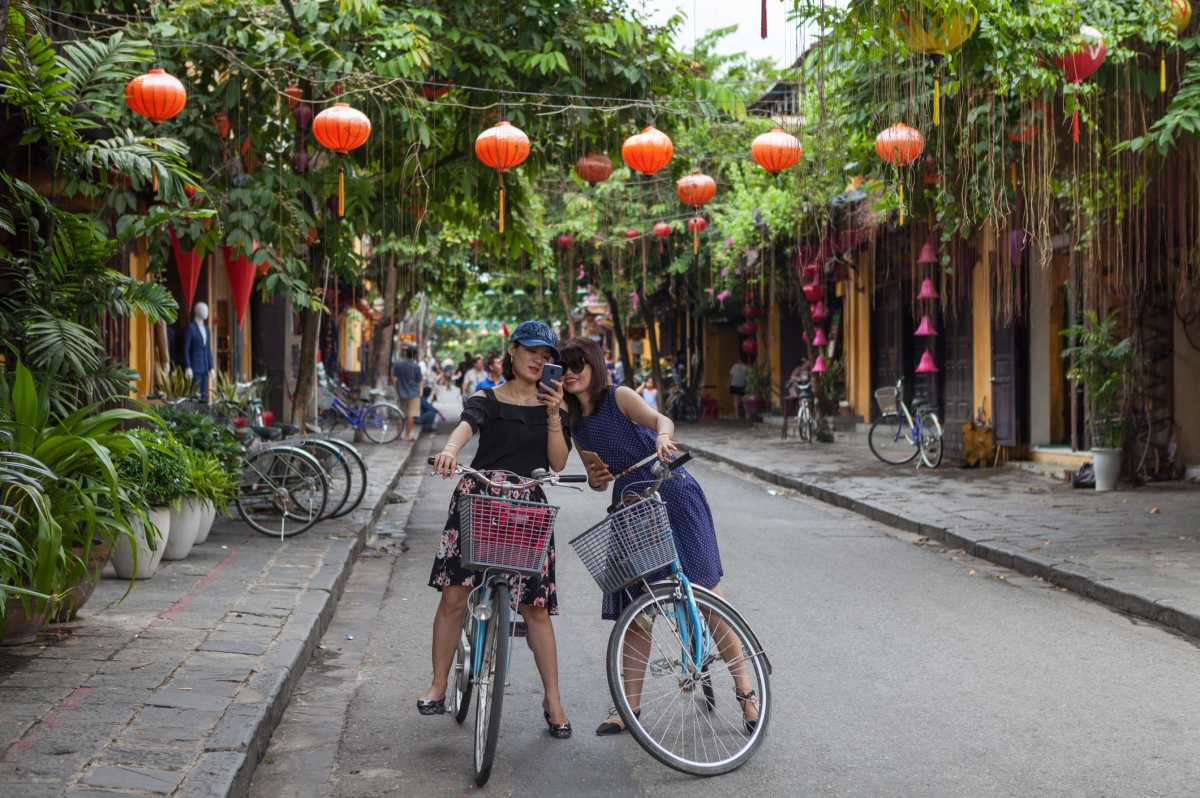 Cyclist on street with yellow buildings and lanterns in Hoi-An-Old-Town