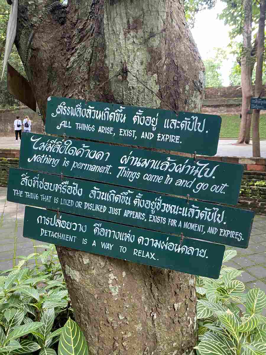 Wooden sign about Buddhist sayings in both English and Thai languages