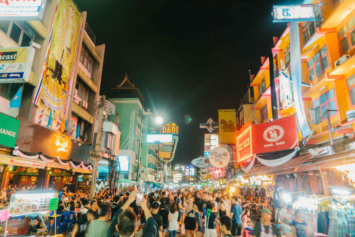 Vibrant night market with neons and many tourists in Bangkok