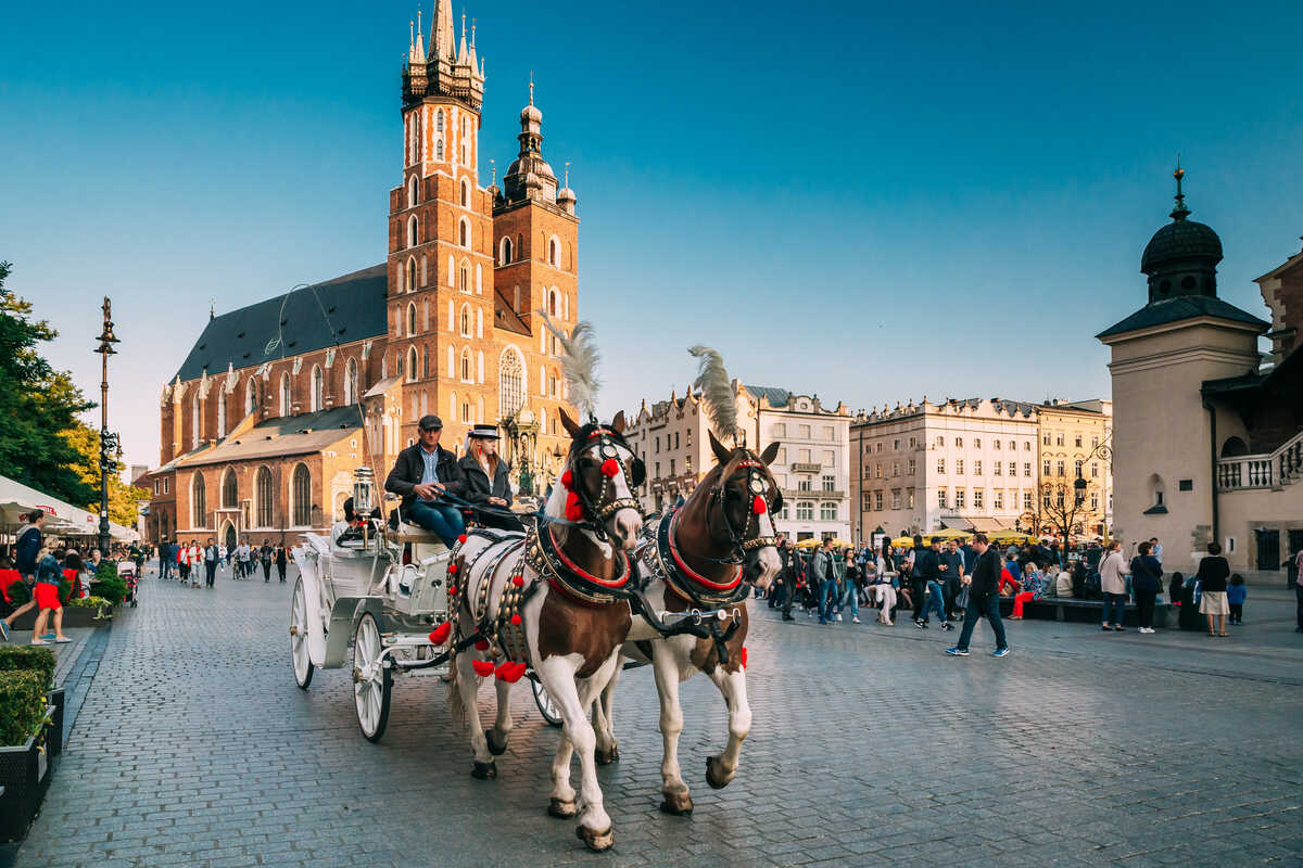 Horse-drawn carriage in a historic market square. 15-Best-Things-to-Do-in-Krakow