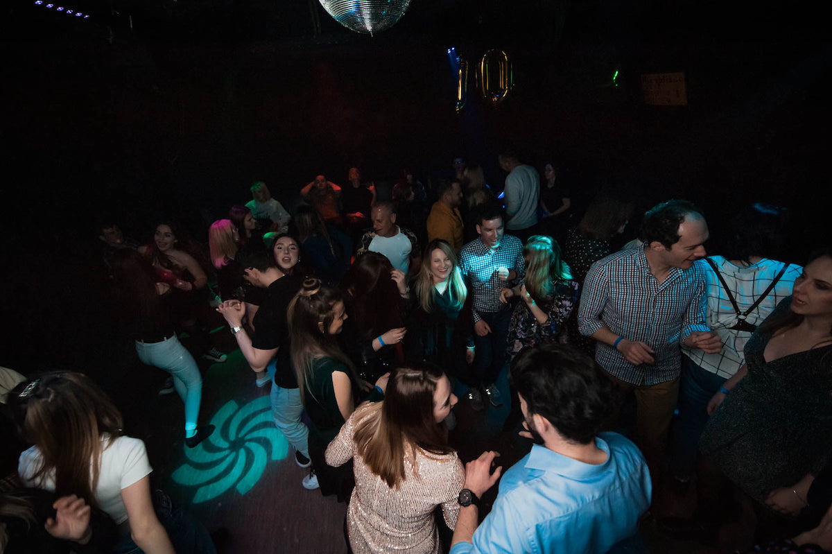 People dancing in a dimly lit club in Krakow - Best Things to Do in Krakow at night