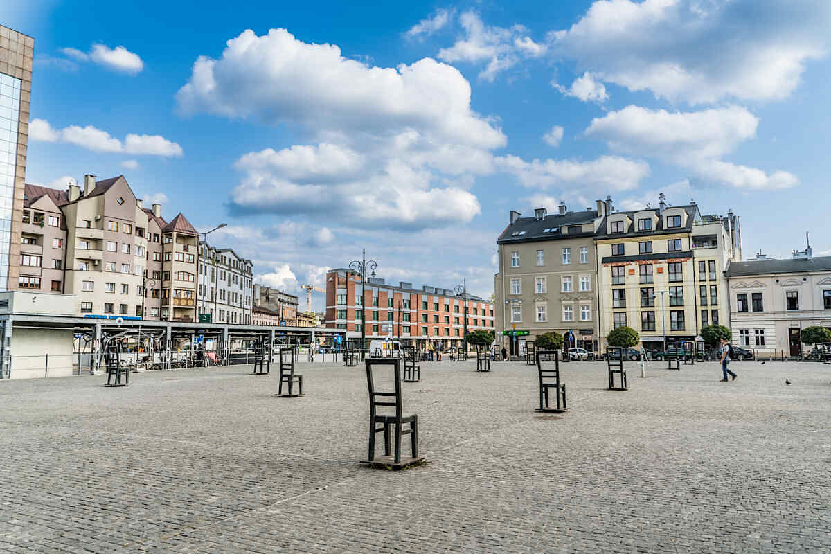Wide city square with historic buildings and chairs