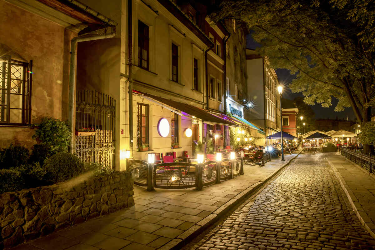 Cobblestone street with buildings at night in the Jewish quarter of Krakow - Best Things to Do at Night in Krakow