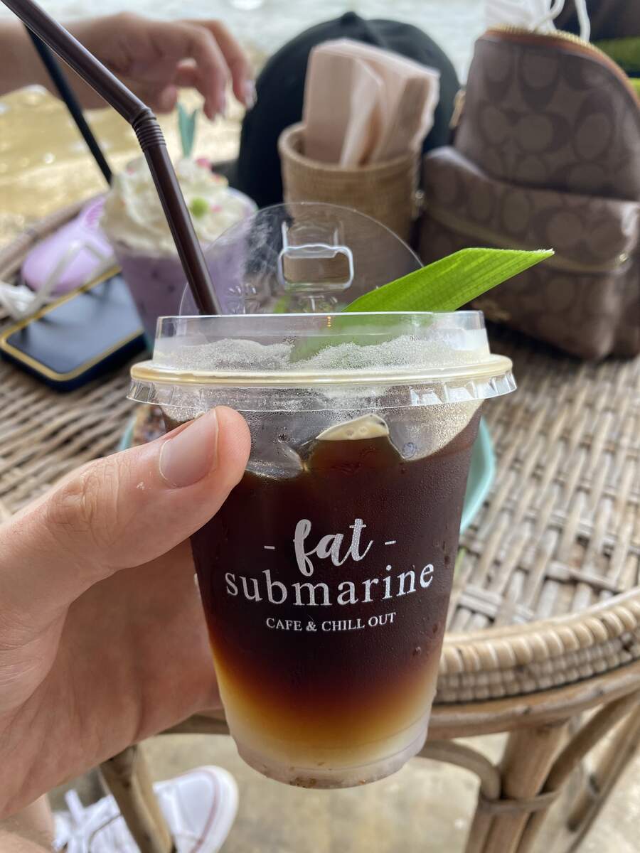 Iced drink in a takeaway cup with a leaf.