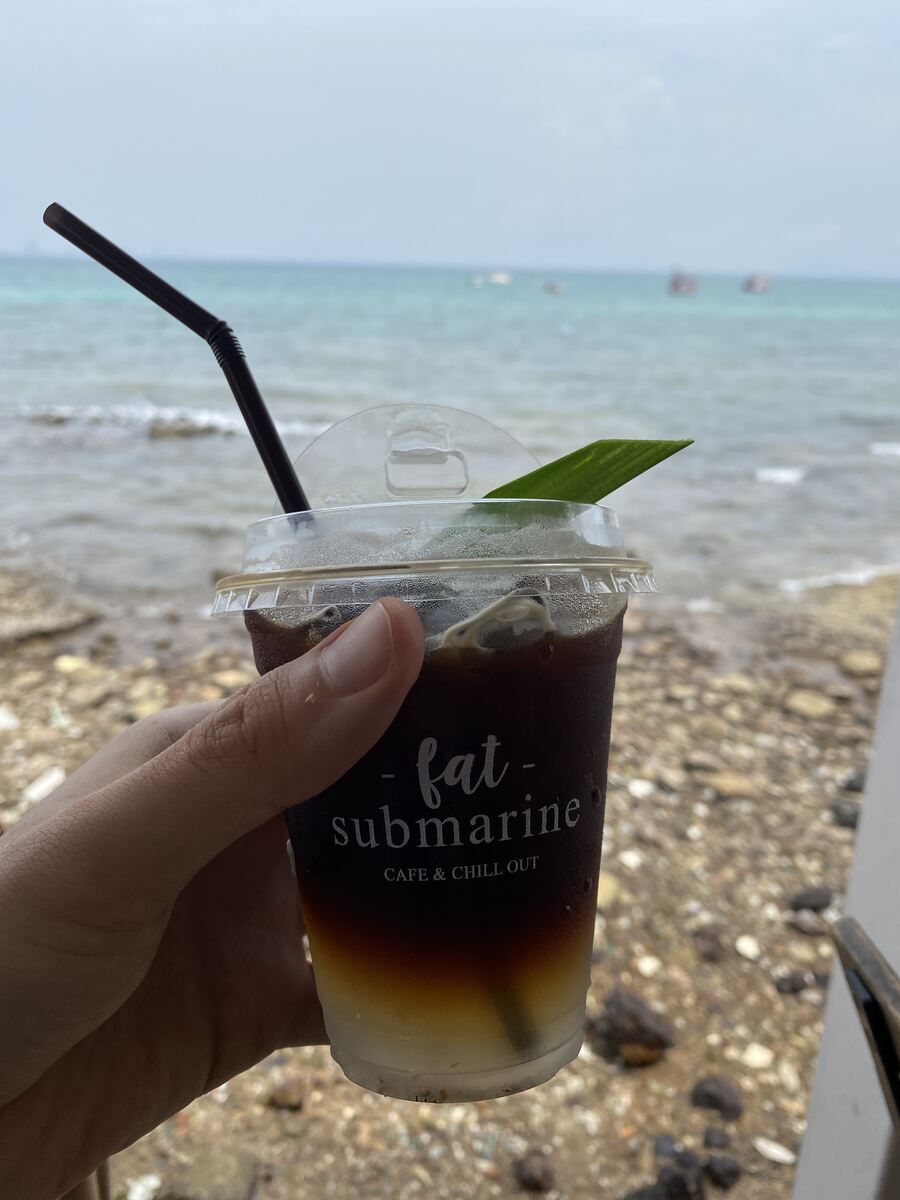 Iced drink in a takeaway cup with the sea in the background