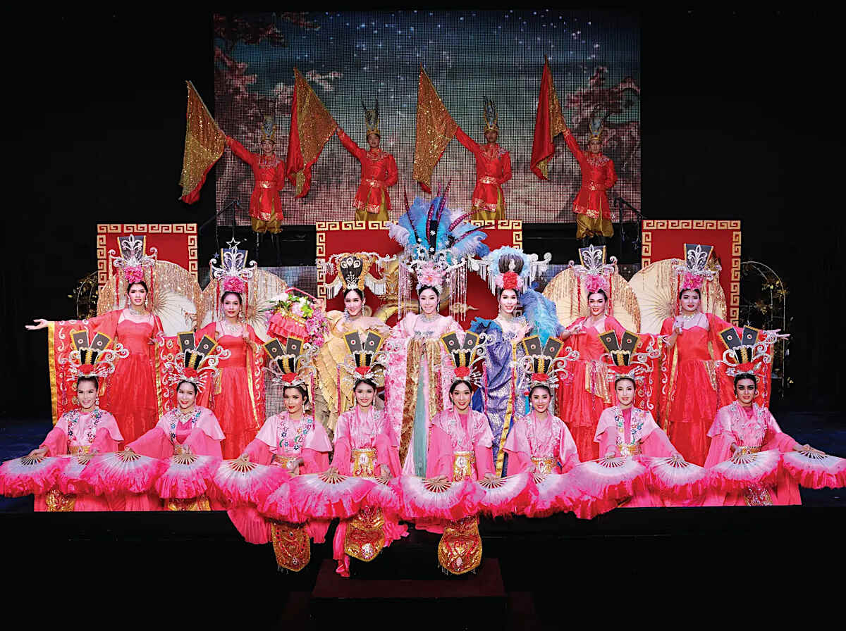 A traditional stage performance with elaborate pink costumes and a festive atmosphere.