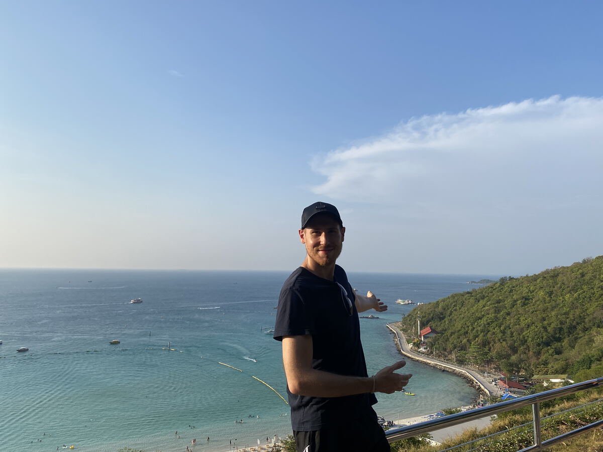 Man standing on a hill with ocean horizon. Tawaen Beach from above