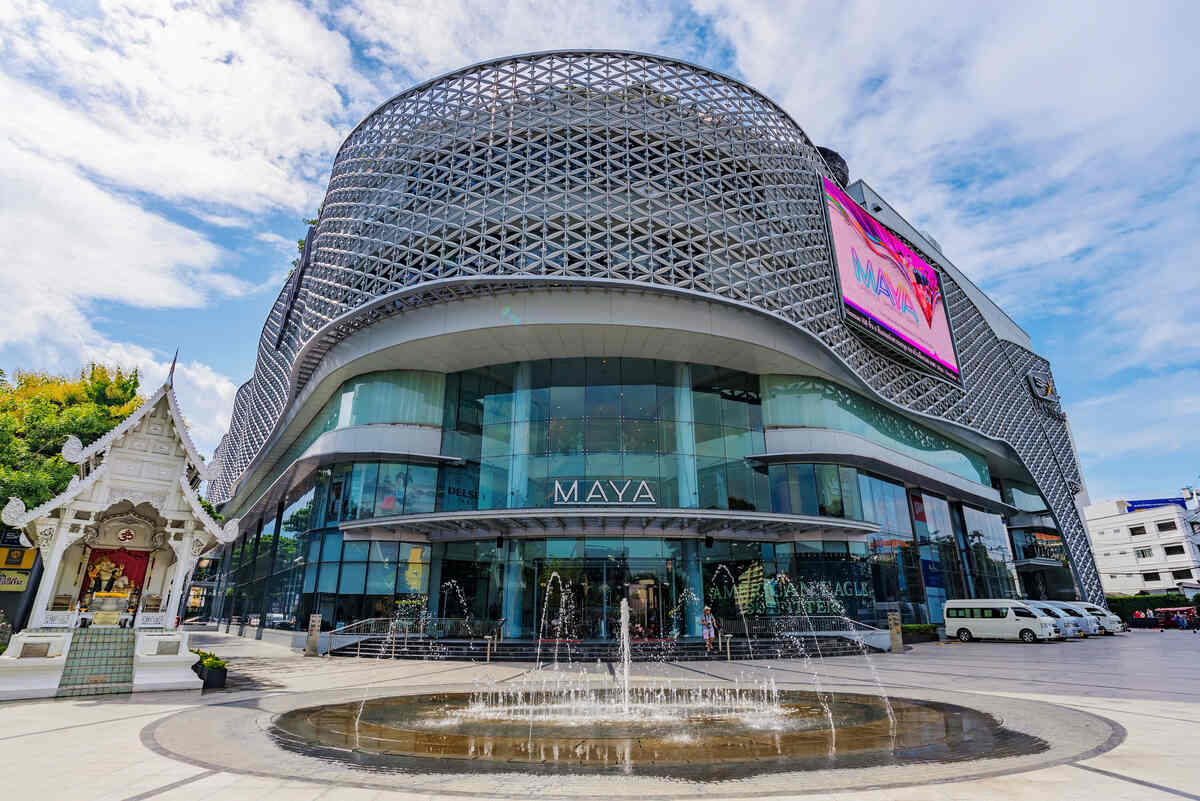 A modern shopping mall with a distinctive curved design and a reflective facade.