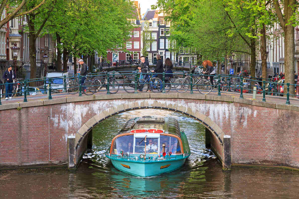 Canal boat approaching under a bridge.