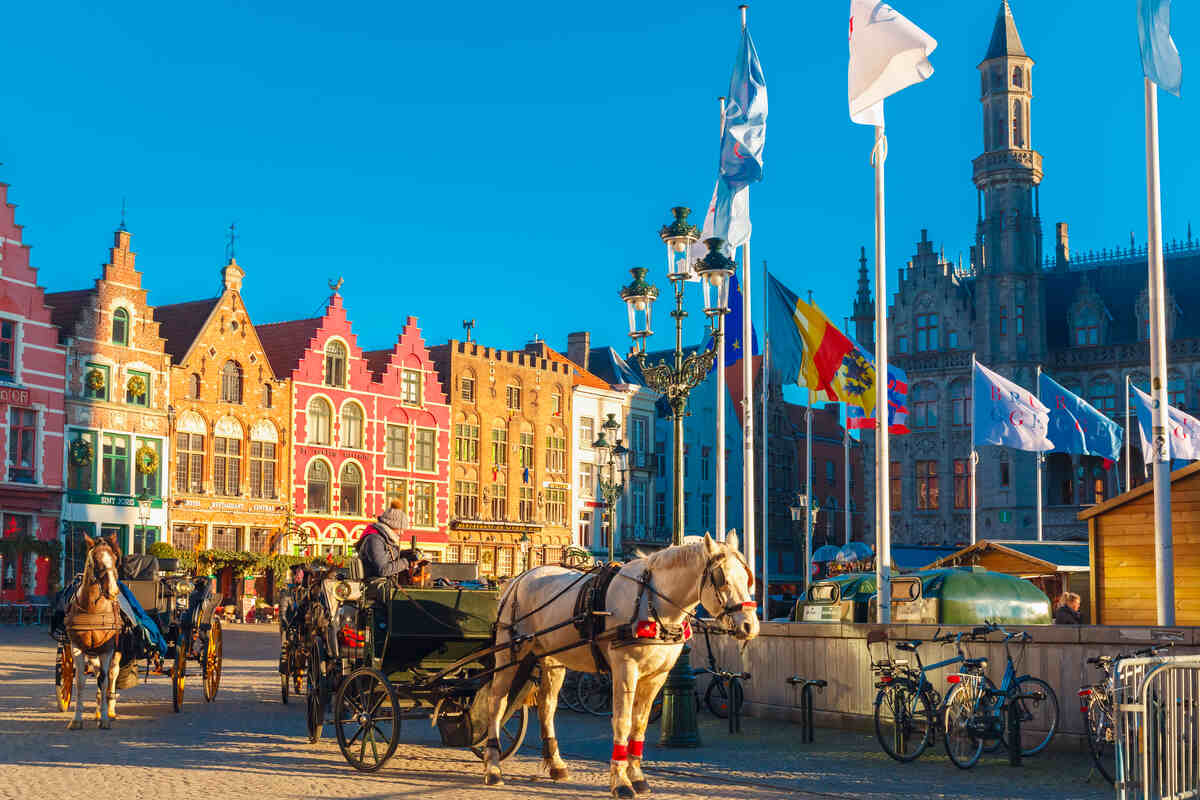 Main Square in Bruges with horse carriage on a sunny day