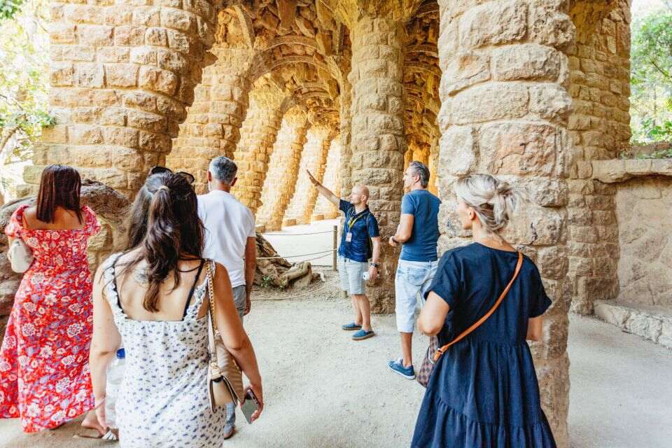 People walking through stone arches at Park Guell.