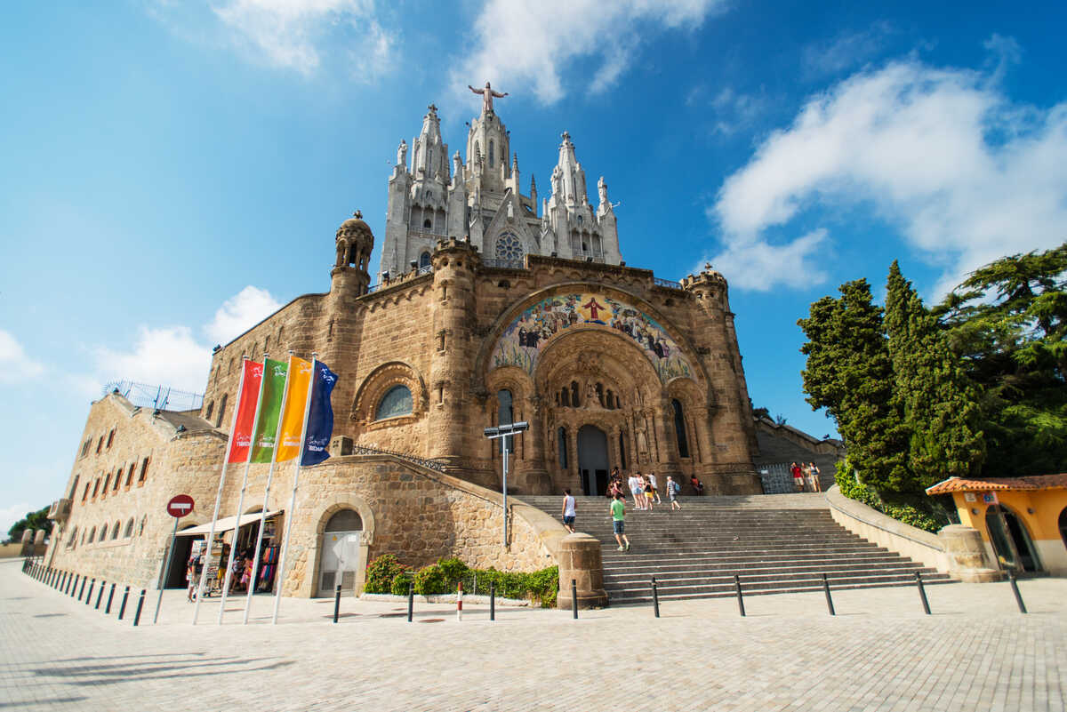 Visiting Mount Tibidabo in Barcelona - Church on a hill with flags.