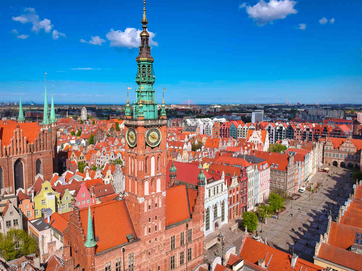 Urban square with pedestrians and cyclists. Gdansk Main Town Hall landmarks in Poland