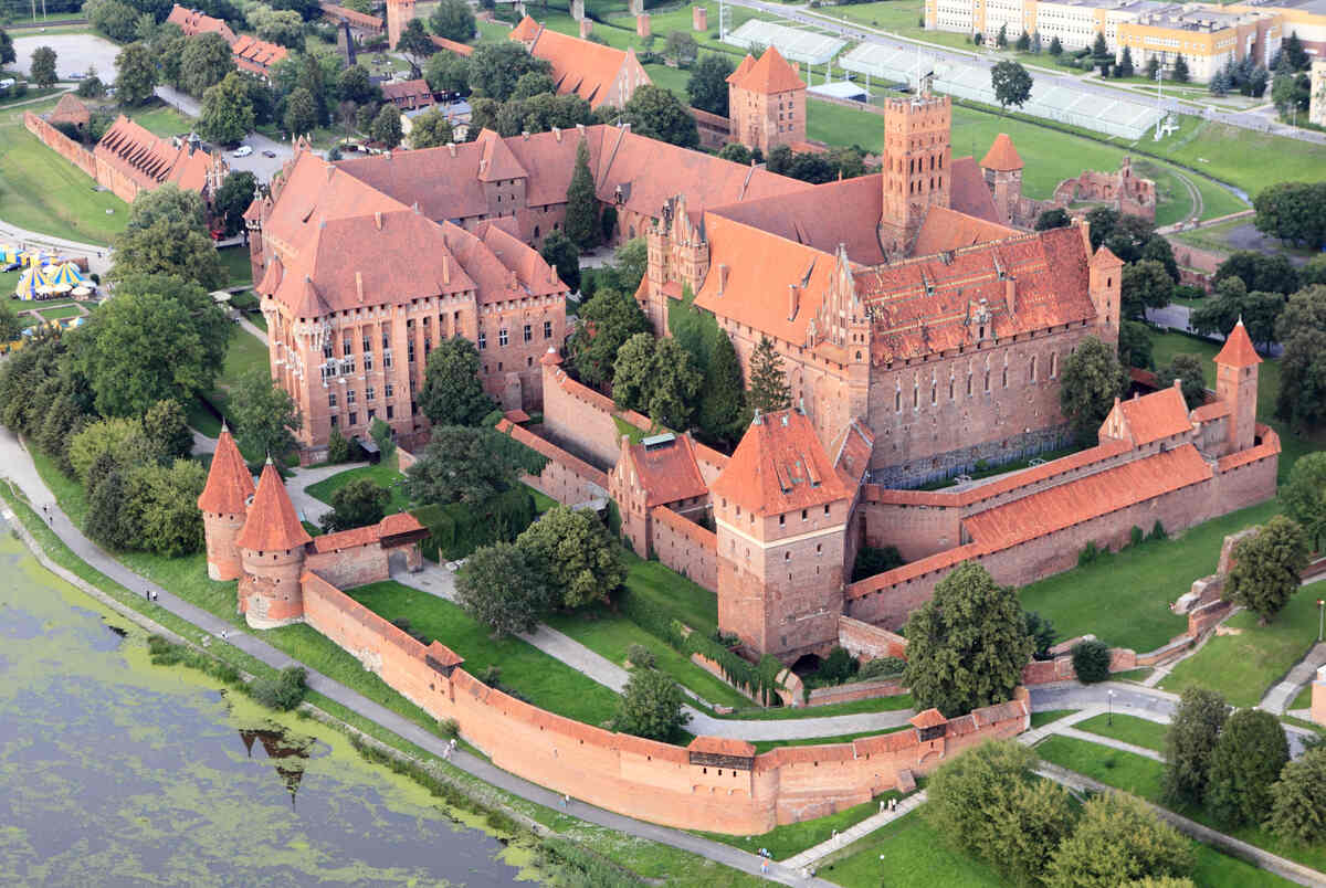 Aerial view of a medieval red-roofed castle.
