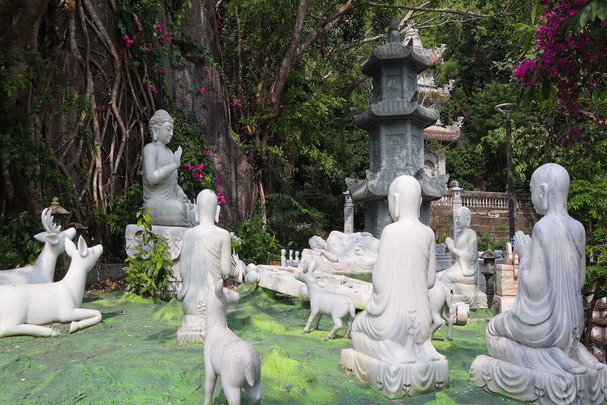 Buddhist garden statues in a serene setting.