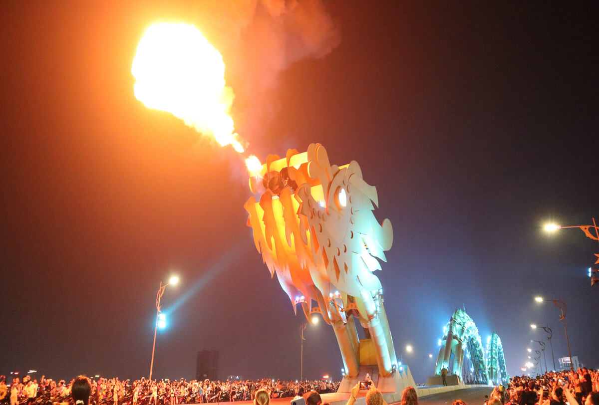 Giant flaming bridge during a festival.