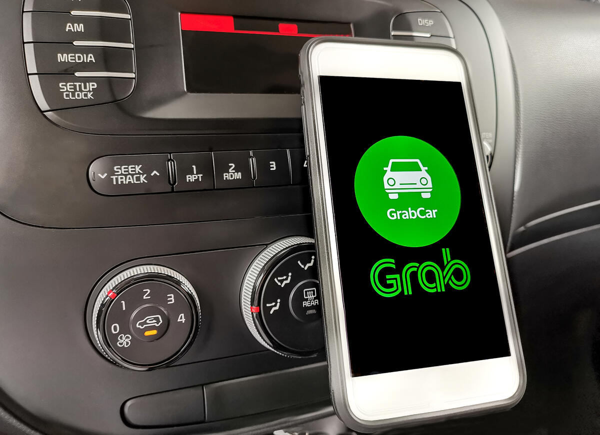 Grab ride-sharing app on car dashboard.