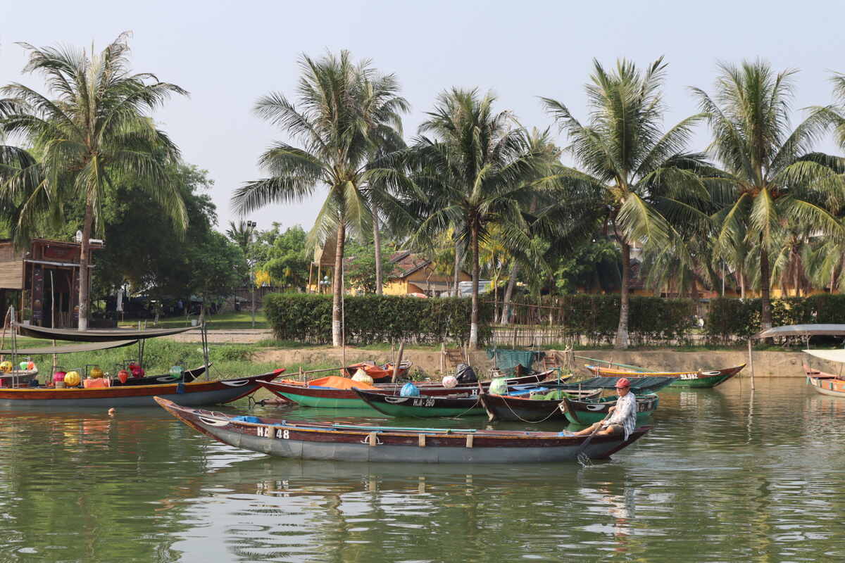 Boats docked along a peaceful river.