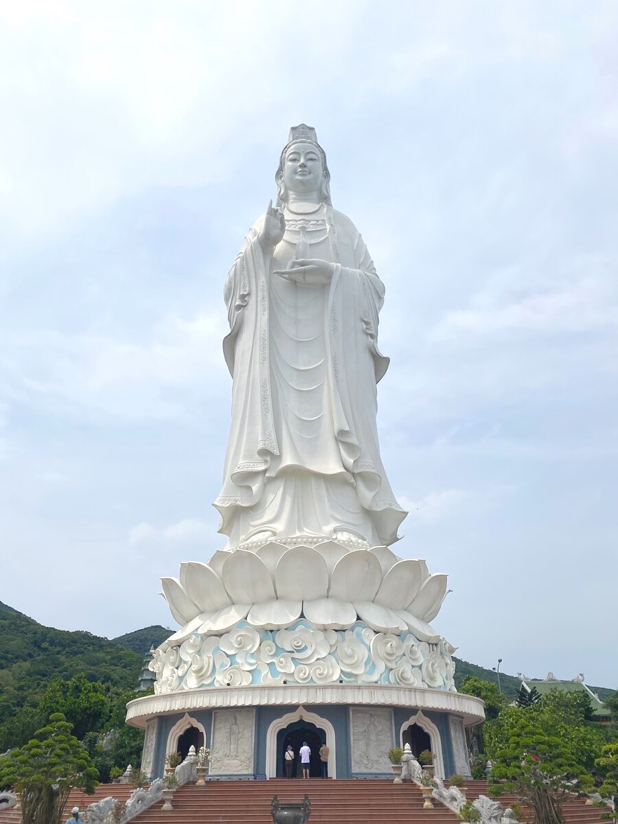 Large white Buddha statue overlooking a mountainous landscape. Da Nang Lady Buddha statue