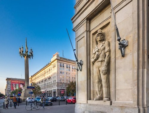 Urban street with classical architecture and statues.