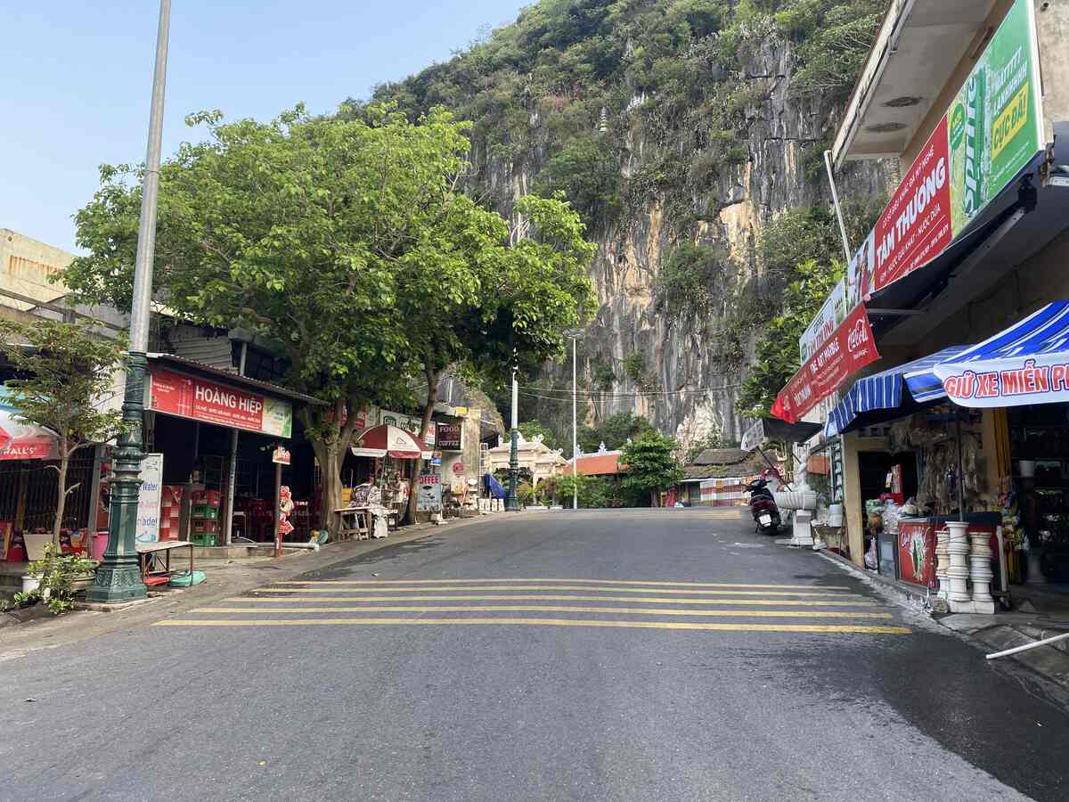 Quiet street in a rock mountain setting with shops showing the entrance to marble mountains.