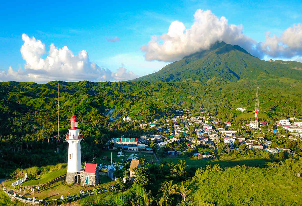 Aerial view of Basco Lighthouse in Batanes with Mount Iraya in the background.