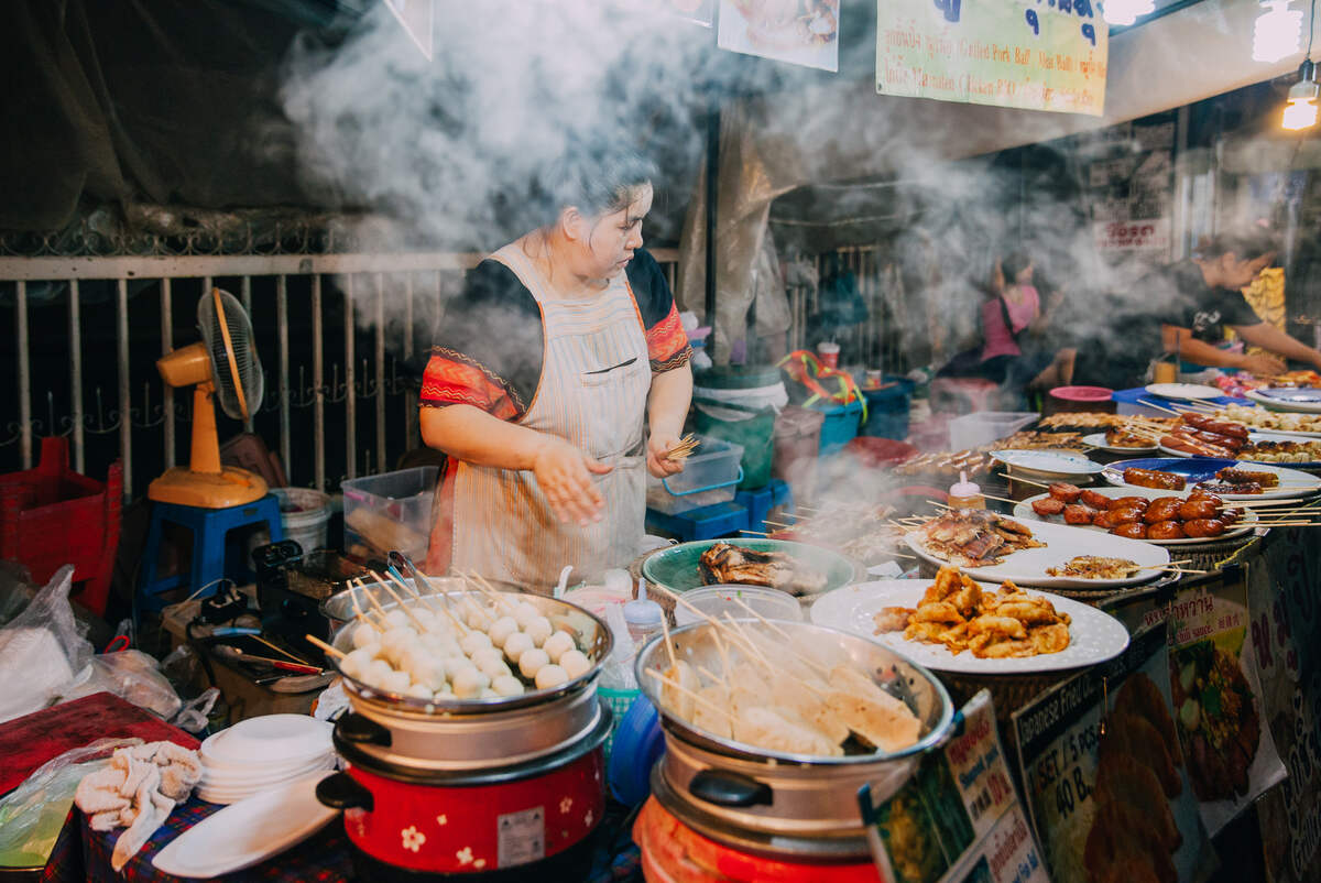 Street vendor cooking at a bustling market.