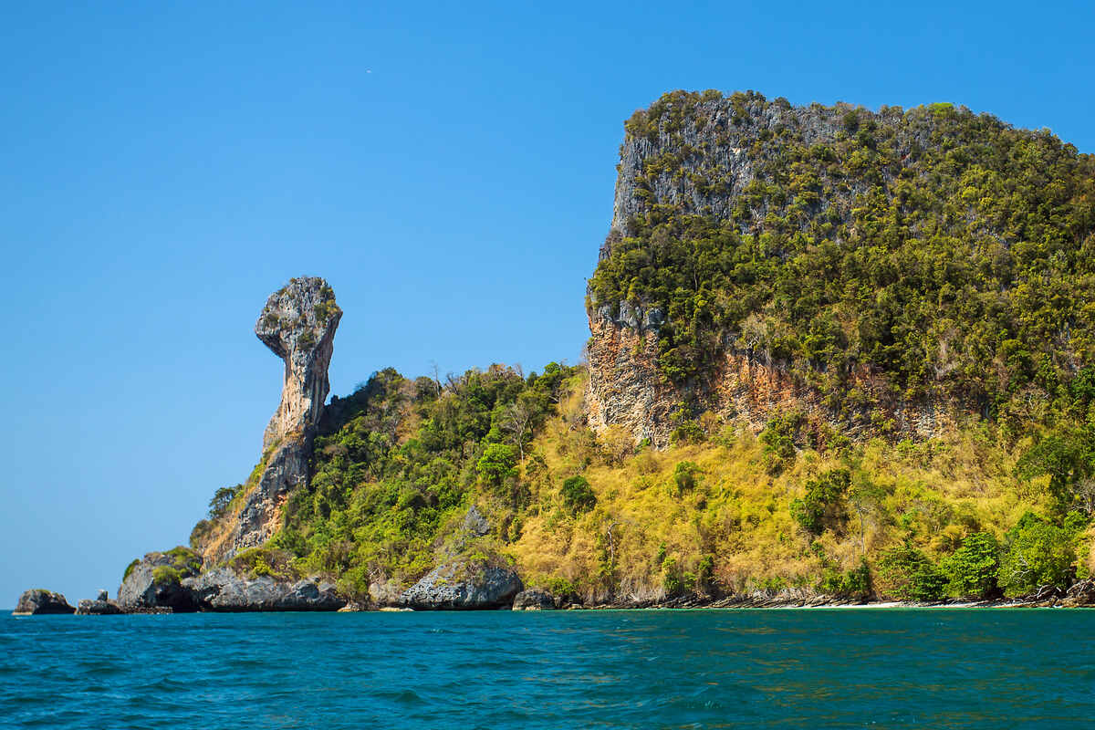 Towering limestone cliffs with green foliage.