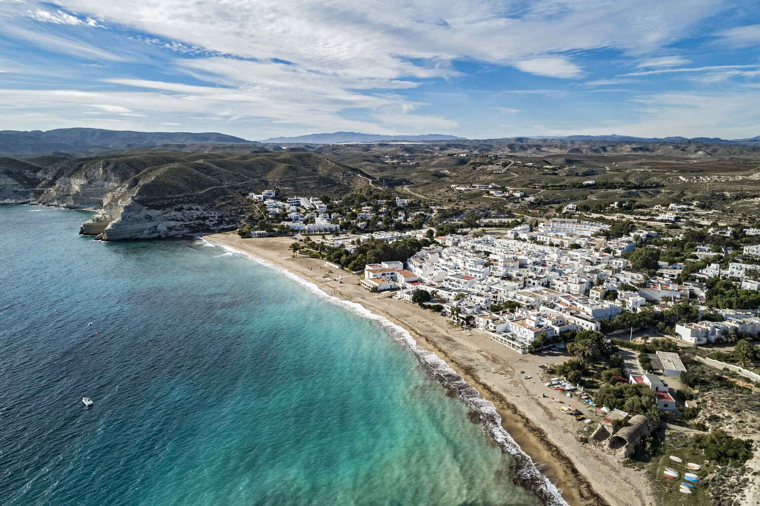 Aerial view of the city of Almeria with blue waters and white-washed town near a mountainous background
