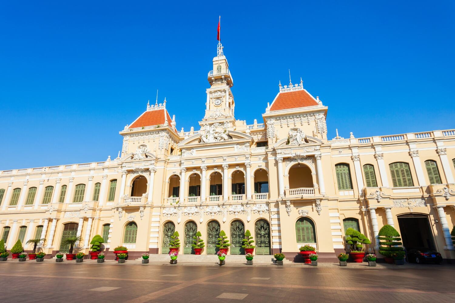 Classic French colonial architecture of the Ho Chi Minh City Hall under clear blue skies.