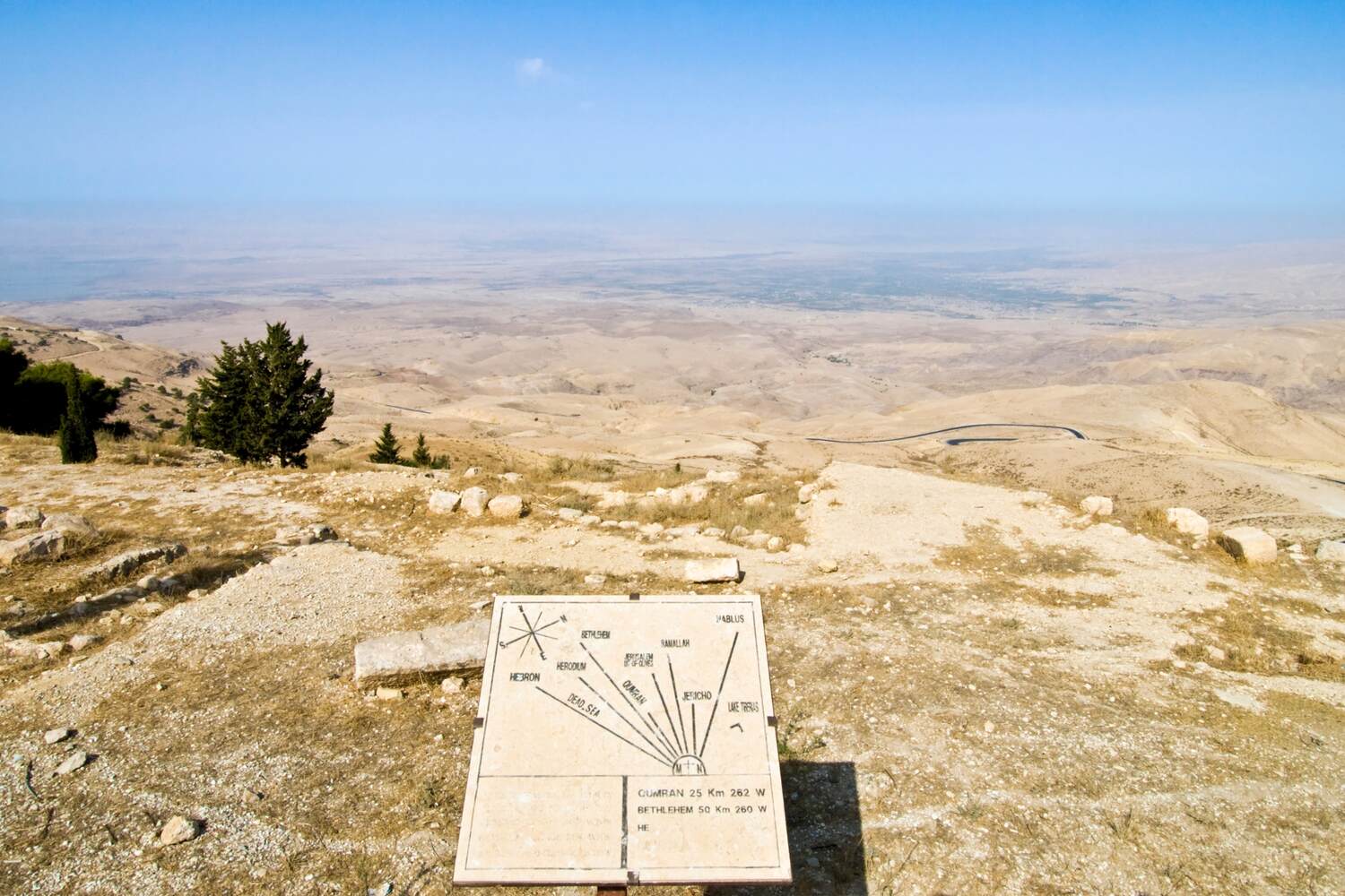Arid landscape with informational signboards.