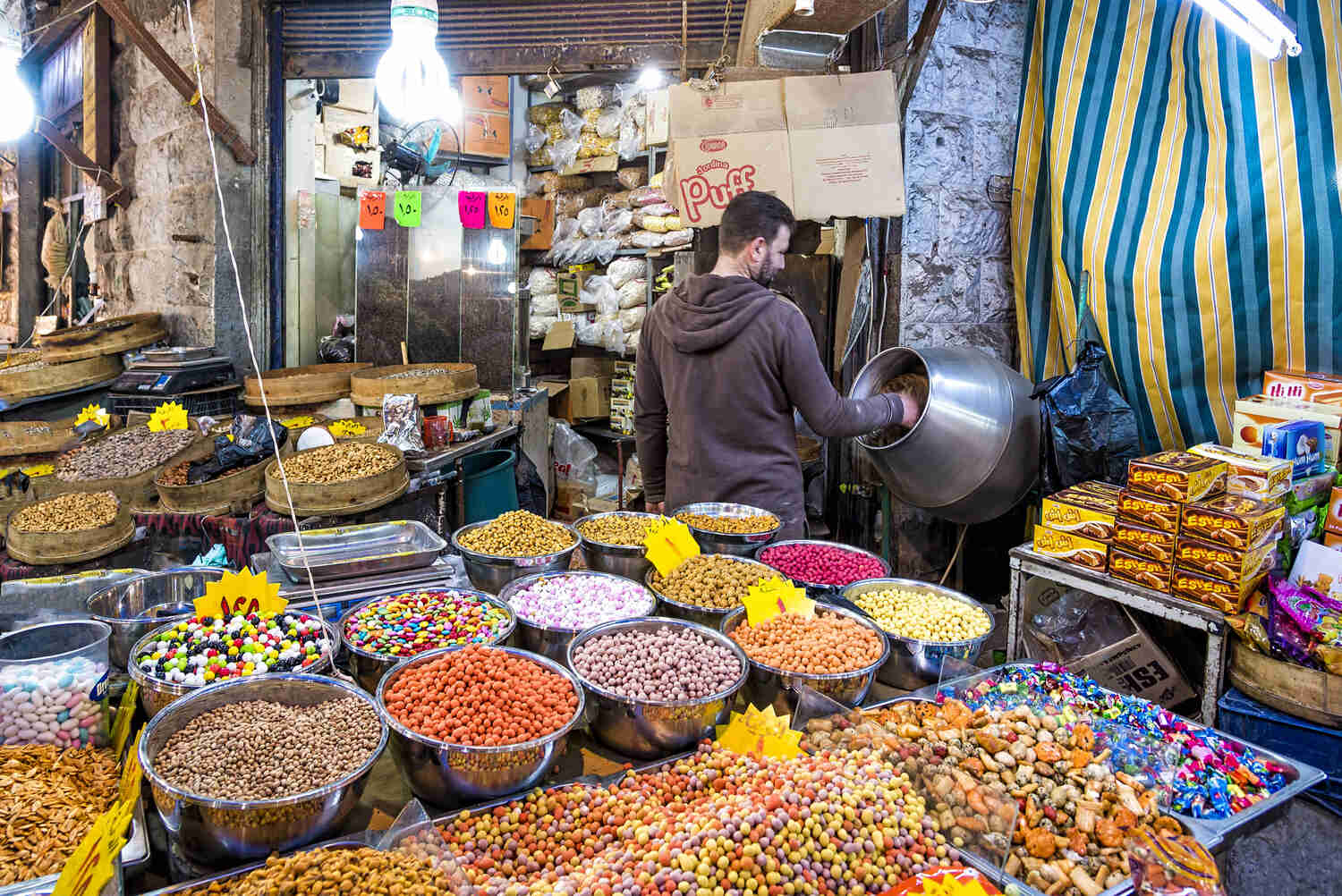 Man working amidst a vibrant spice market.