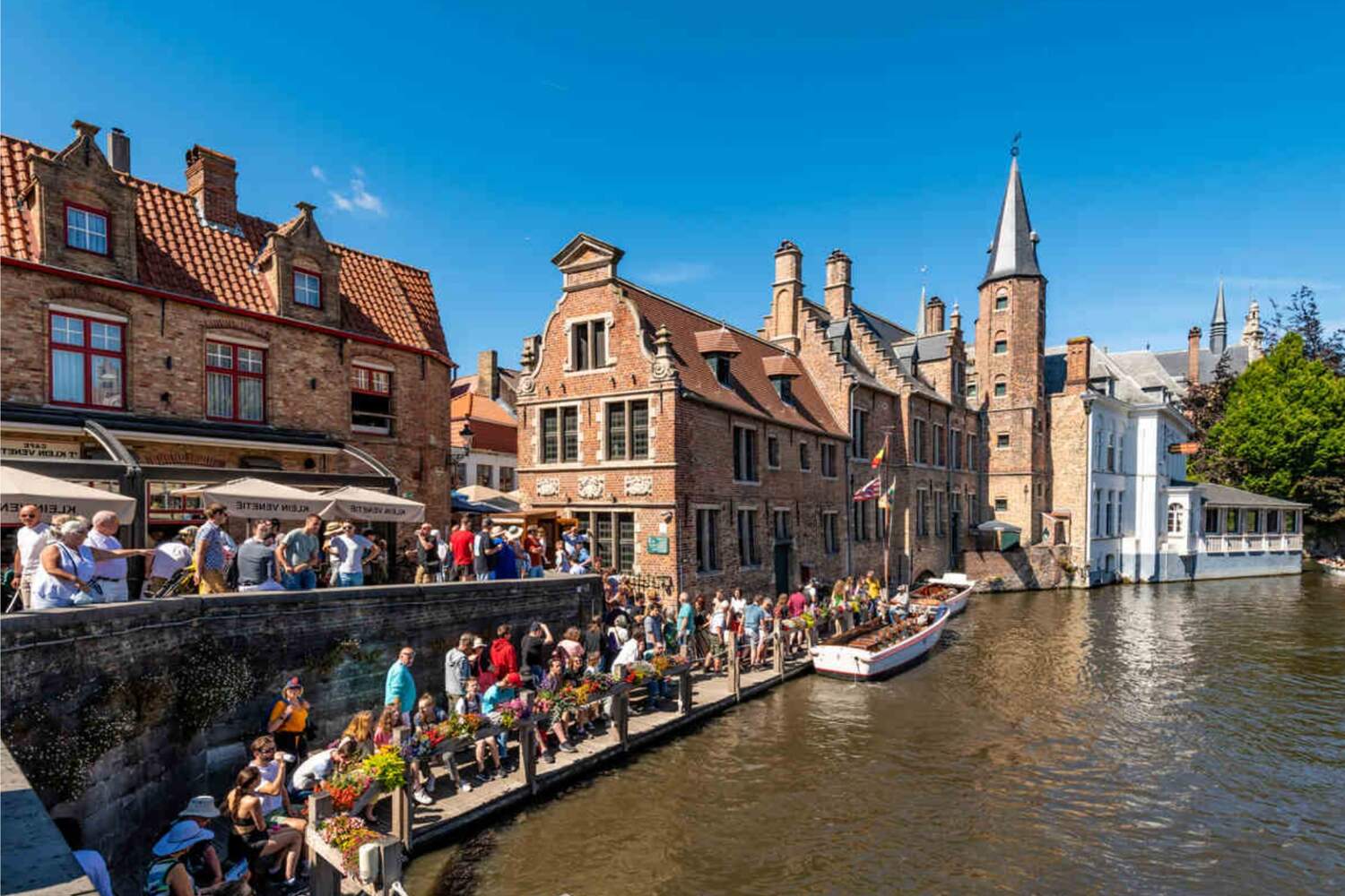 Crowds of tourists waiting for the Bruges Canal tours in Belgium