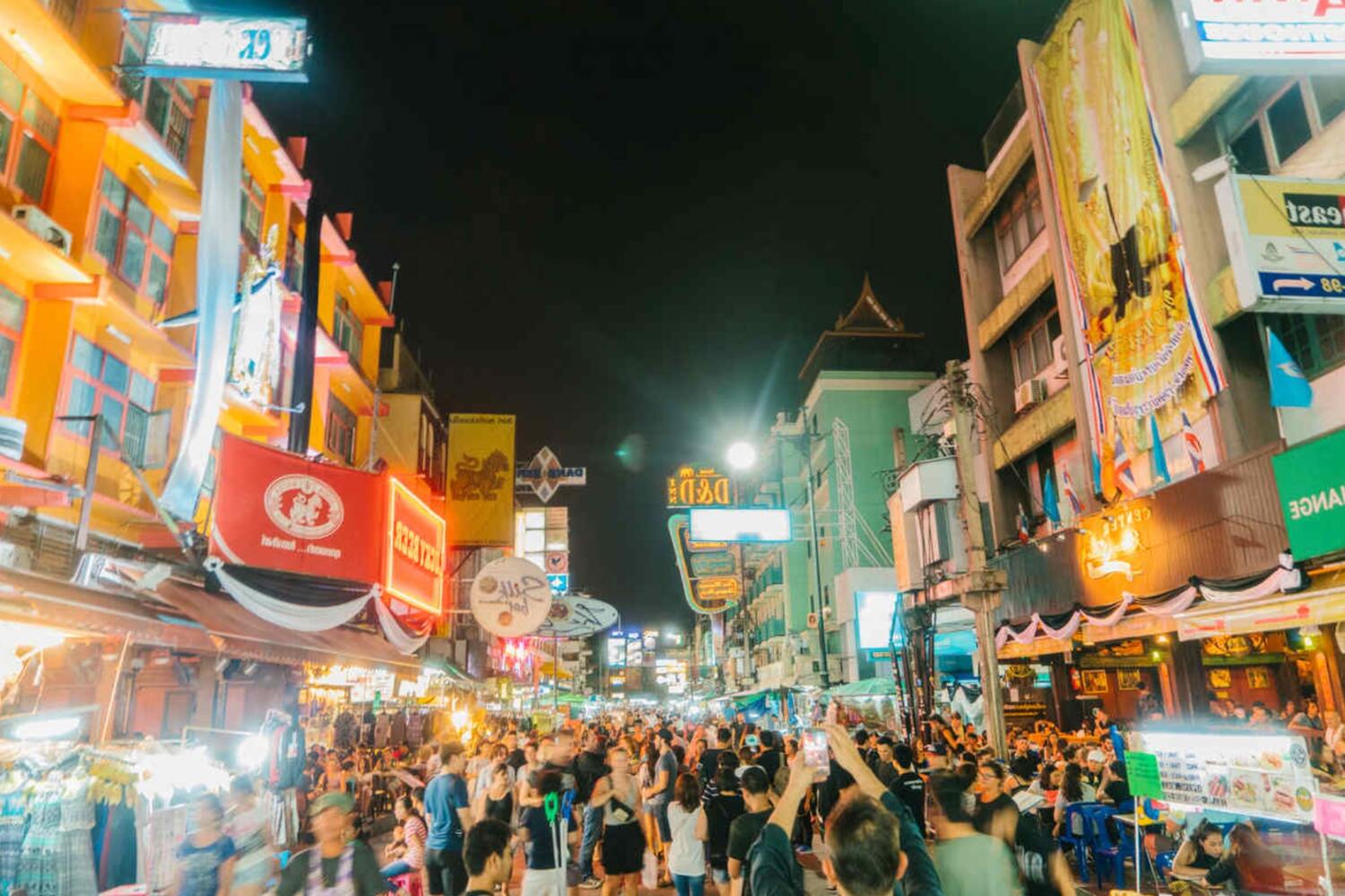 Vibrant night market with neons and many tourists in Bangkok