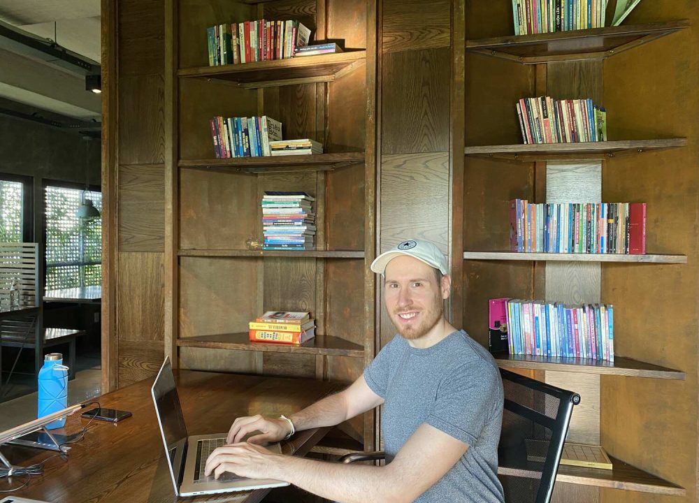 Man working at a laptop in a café.